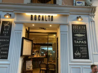 Ein einladendes Restaurant mit dem Namen "Bocalto". Die Vorderseite zeigt eine stilvolle Außenansicht mit Menüs und gemütlichen Sitzgelegenheiten.