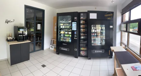 Eine moderne Verkaufsstelle mit zwei Snack- und Getränkeautomaten. Neben den Automaten steht eine Kaffeebar zur Verfügung.