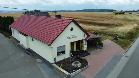 Ein gemütliches Haus mit rotem Dach in ländlicher Umgebung.