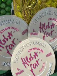 Drei Medaillen vom Herbstfestzug sind sichtbar. Sie zeigen den Text "Herbstfest" und verschiedene Platzierungen sowie den Schriftzug "Ich bin dabei."