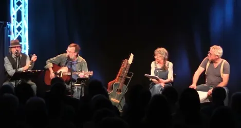 Eine Live-Performance mit vier Künstlern auf der Bühne. Sie spielen Musik und interagieren mit dem Publikum.