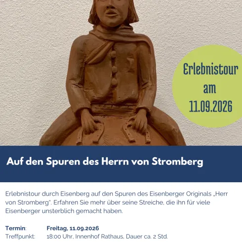 Eine Holzfigur eines Mannes, die in traditioneller Kleidung dargestellt ist. Der Hintergrund enthält Informationen zu einer Veranstaltung in Eisenberg.